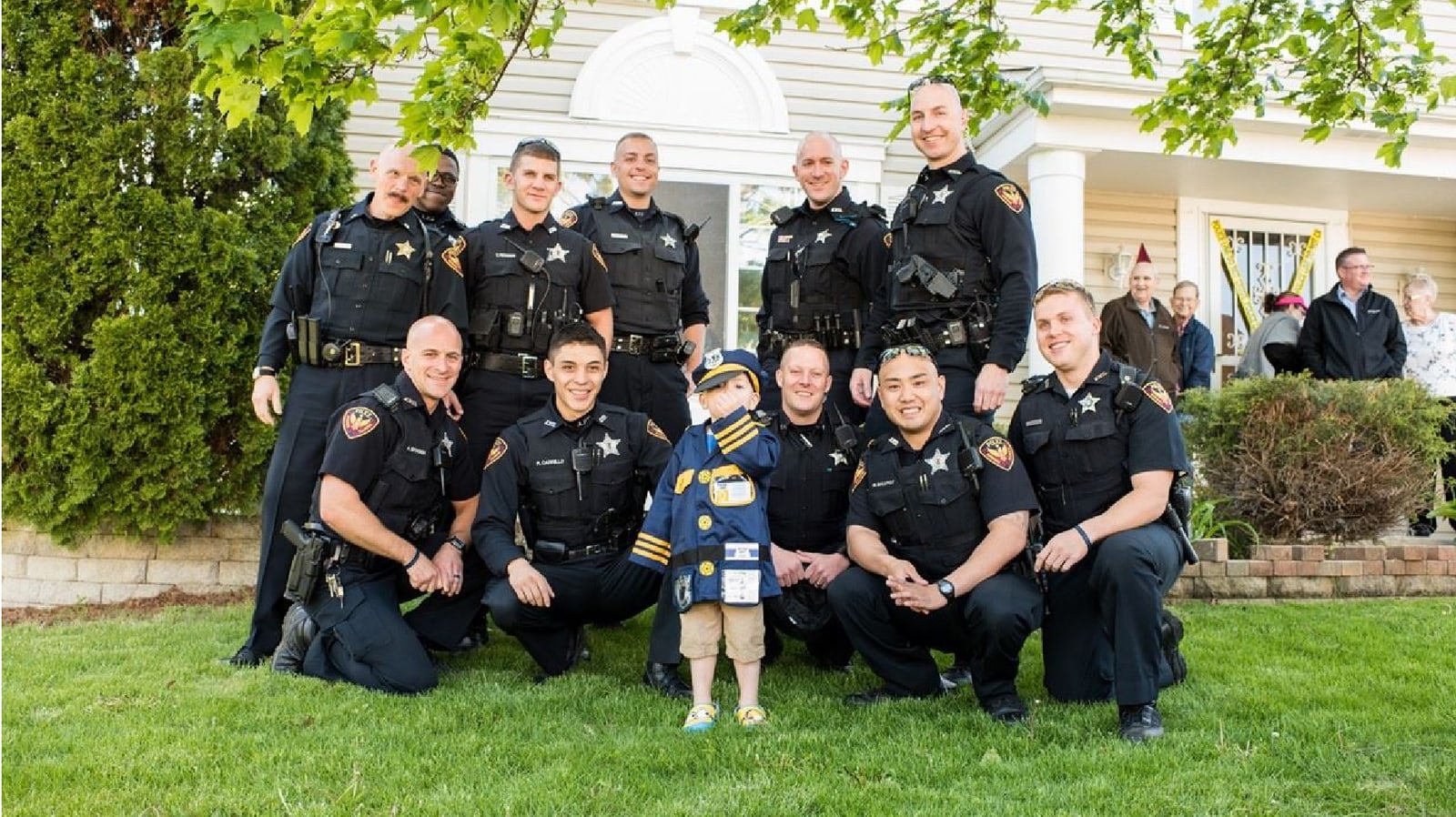 Law enforcement officers gathered with a young scout
